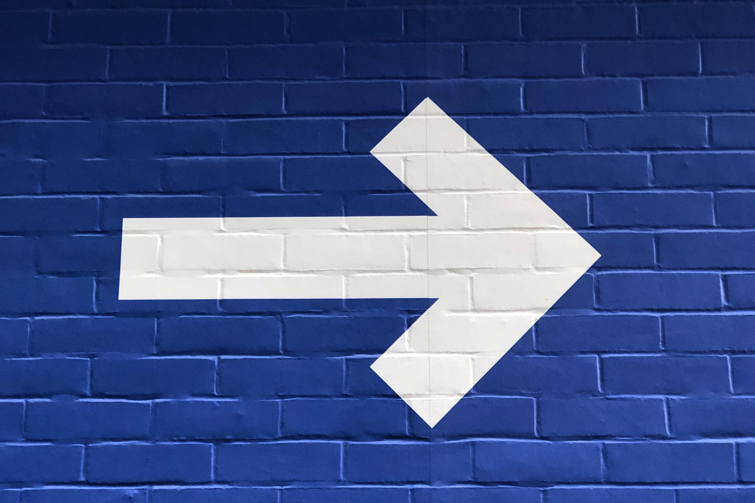 Arrow on blue wall pointing right